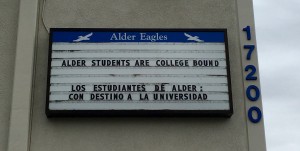 School sign reading "Alder Students Are College Bound" and "Todos Estudiantes De Ader Son Destino A La Universidad